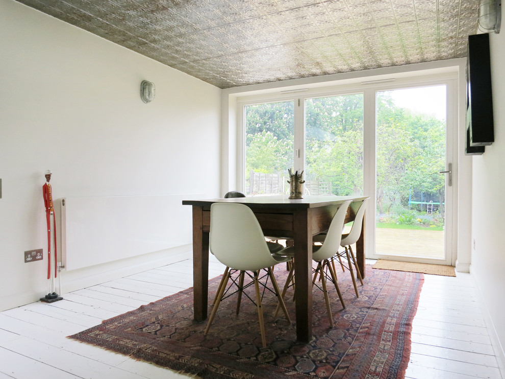 Cette photo montre une salle à manger éclectique avec parquet peint et un sol blanc.
