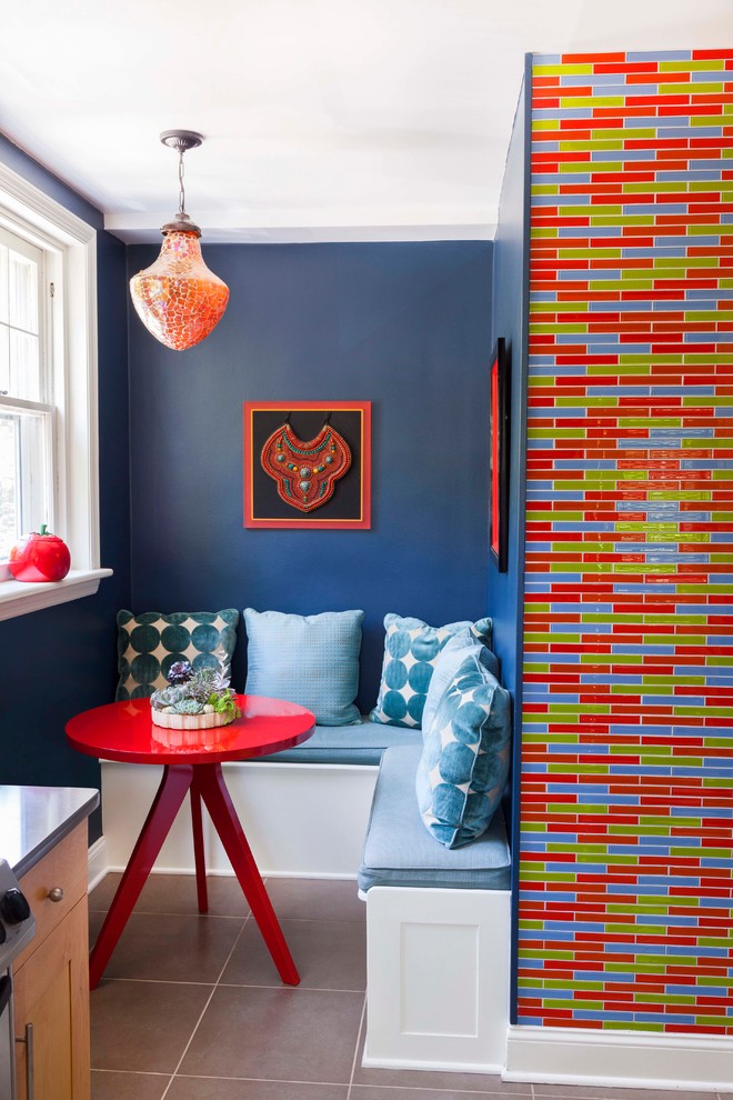 Cette image montre une petite salle à manger ouverte sur la cuisine bohème avec un sol en carrelage de céramique et un mur bleu.