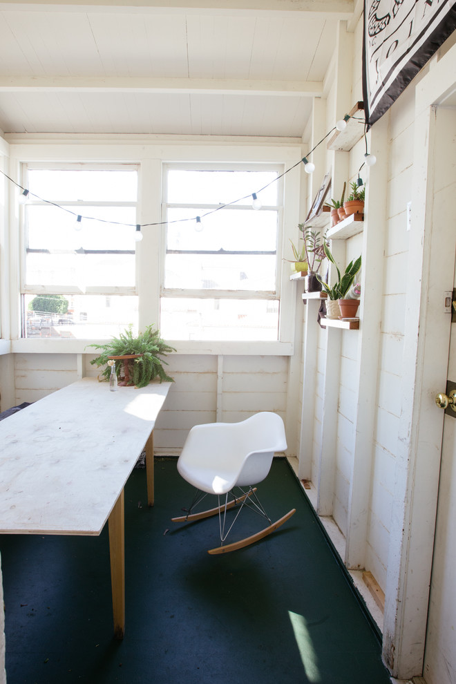 This is an example of a small eclectic enclosed dining room in San Francisco with beige walls, no fireplace and black floors.