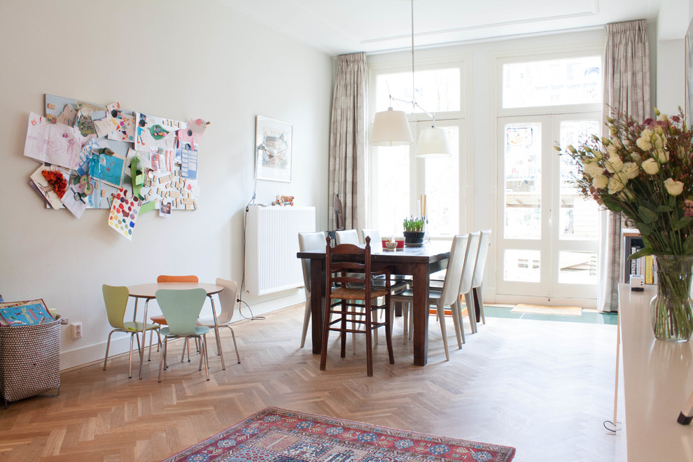 Große Skandinavische Wohnküche ohne Kamin mit weißer Wandfarbe und braunem Holzboden in Amsterdam
