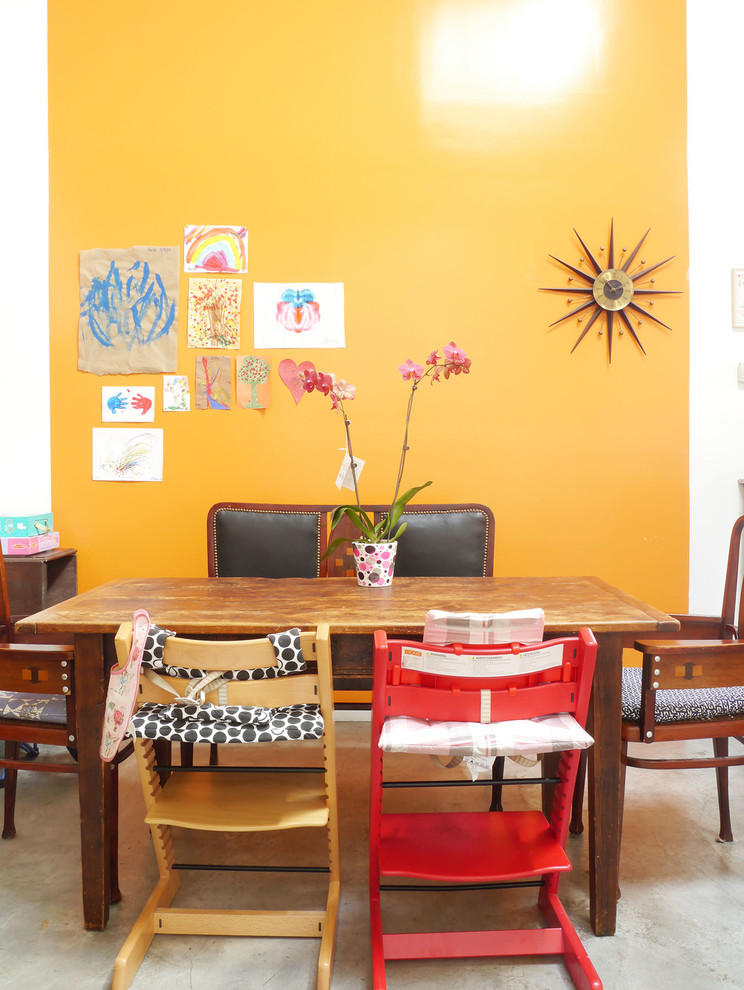 Источник вдохновения для домашнего уюта: гостиная-столовая в стиле фьюжн с бетонным полом и желтыми стенами