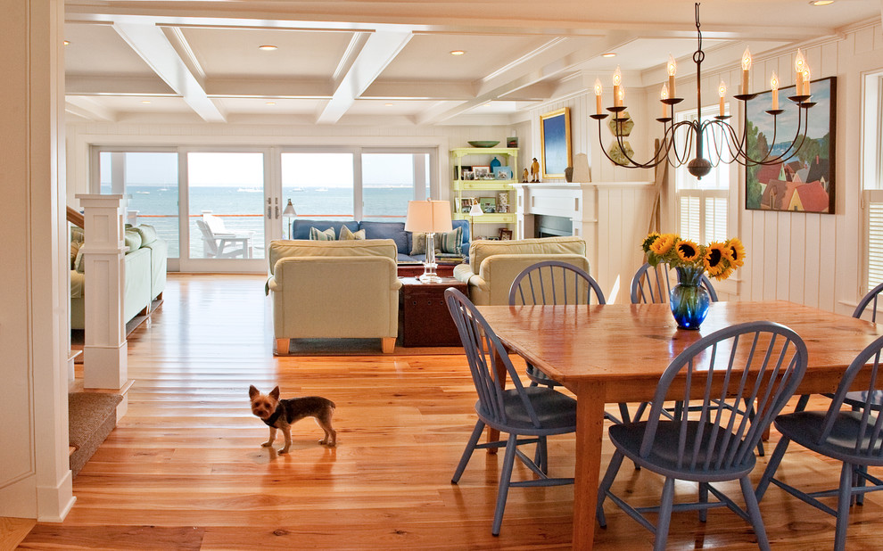 Ispirazione per una sala da pranzo costiera con pareti bianche e pavimento in legno massello medio