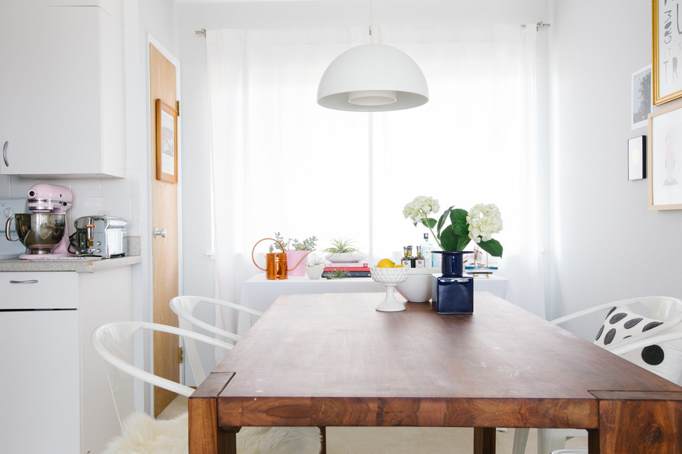 Cette image montre une salle à manger ouverte sur la cuisine traditionnelle avec un mur blanc.