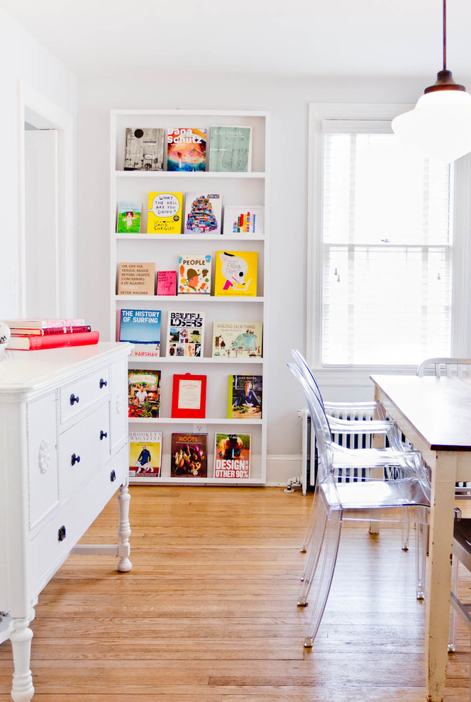 Eclectic medium tone wood floor dining room photo in New York with white walls