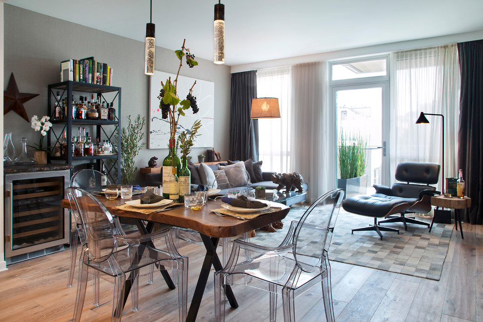 Esempio di una sala da pranzo aperta verso il soggiorno chic con pareti grigie e pavimento in legno massello medio