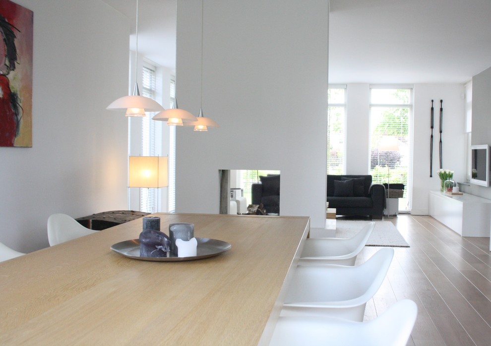 This is an example of a scandi open plan dining room in Amsterdam.