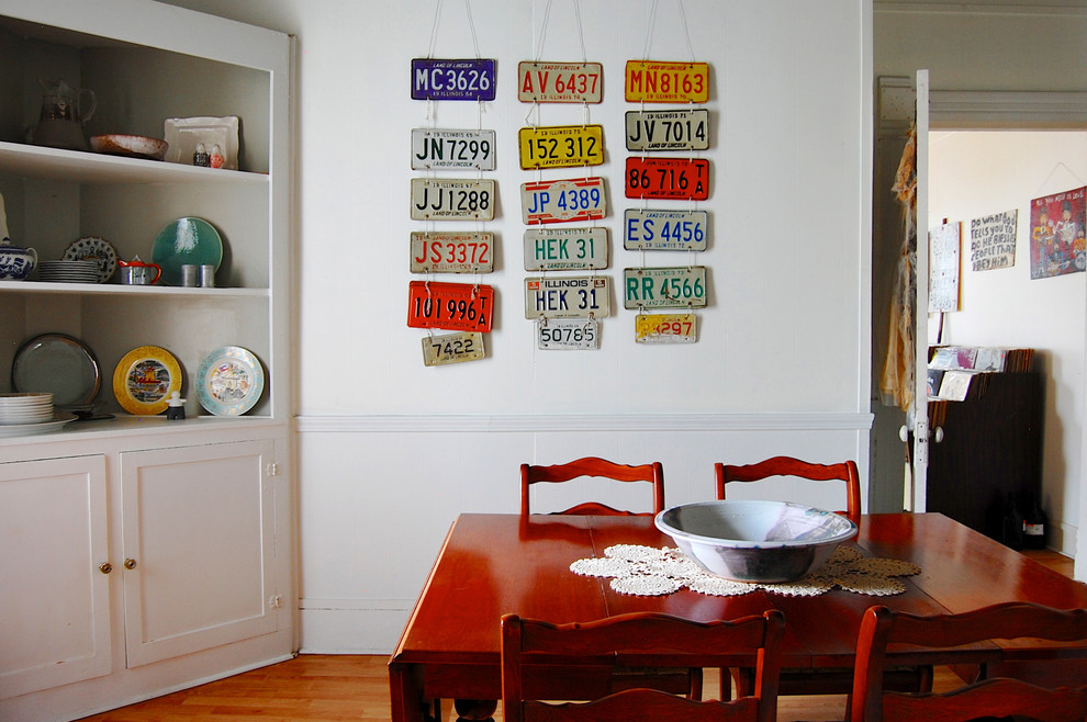 Inspiration for an eclectic dark wood floor dining room remodel in New York with white walls