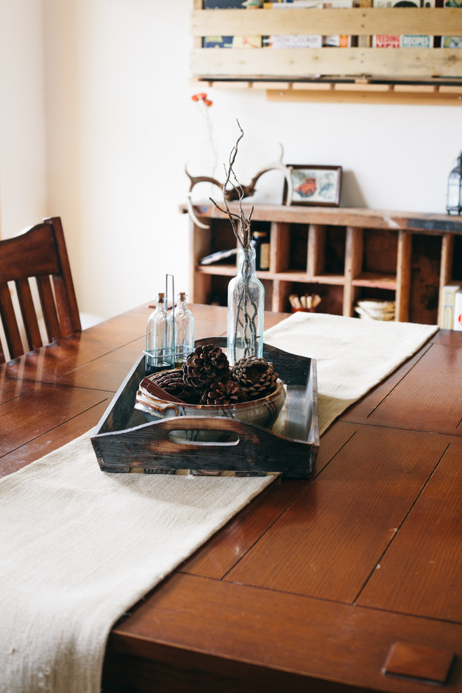 Modelo de comedor campestre pequeño cerrado con paredes blancas y suelo de madera en tonos medios