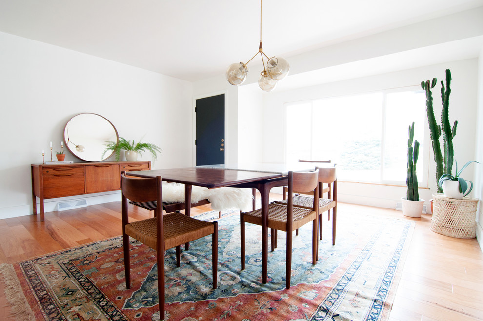Immagine di una sala da pranzo minimalista chiusa e di medie dimensioni con pareti bianche e parquet chiaro