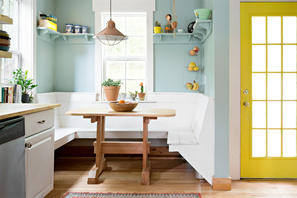 На фото: кухня-столовая в стиле кантри с синими стенами, светлым паркетным полом и бежевым полом с
