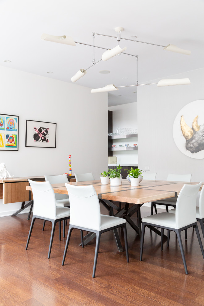 Idées déco pour une salle à manger ouverte sur le salon contemporaine avec un mur gris, un sol en bois brun et un sol marron.