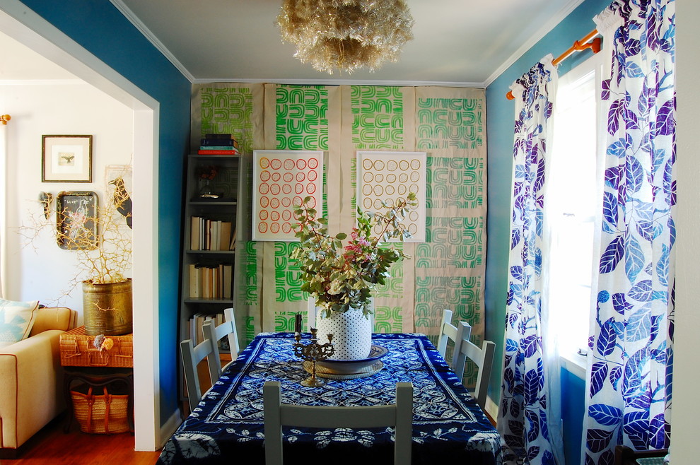 Aménagement d'une salle à manger éclectique avec un mur bleu et parquet foncé.