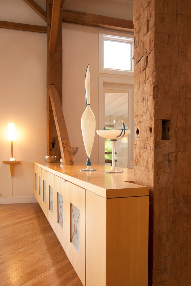 Modelo de comedor de estilo de casa de campo grande abierto sin chimenea con paredes blancas y suelo de madera clara