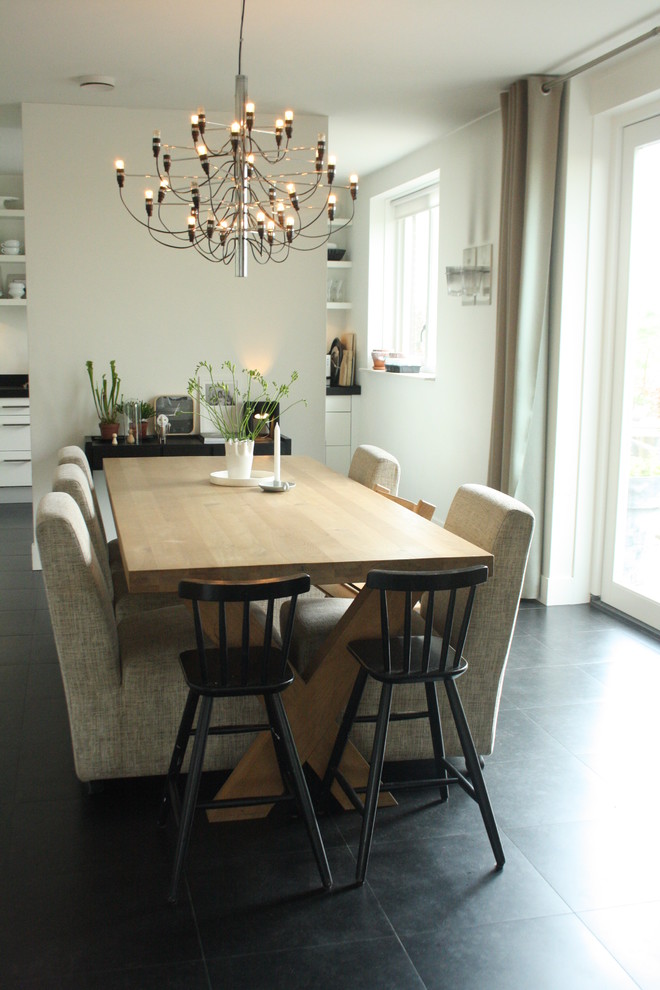 This is an example of a contemporary dining room in Amsterdam with white walls.