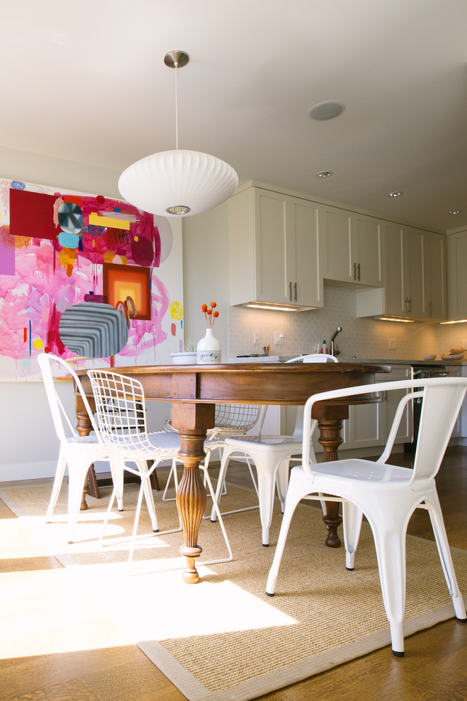Esempio di una sala da pranzo aperta verso la cucina minimal con pareti beige e pavimento in legno massello medio