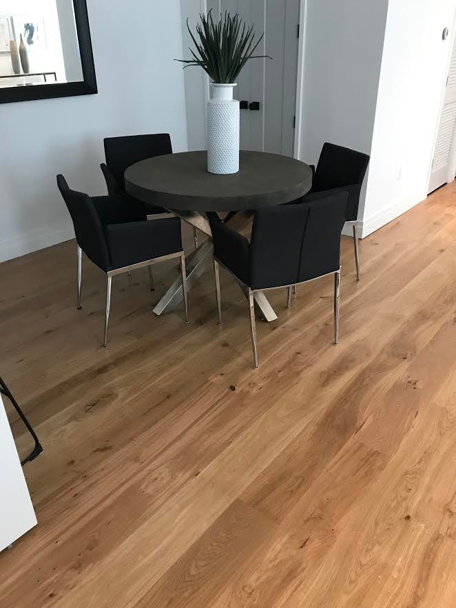 Foto di una piccola sala da pranzo aperta verso il soggiorno design con pareti bianche, pavimento in legno massello medio e pavimento marrone