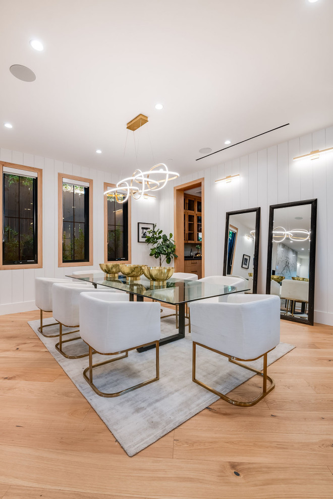 Landhaus Esszimmer mit weißer Wandfarbe, braunem Holzboden, braunem Boden und Holzdielenwänden in Los Angeles