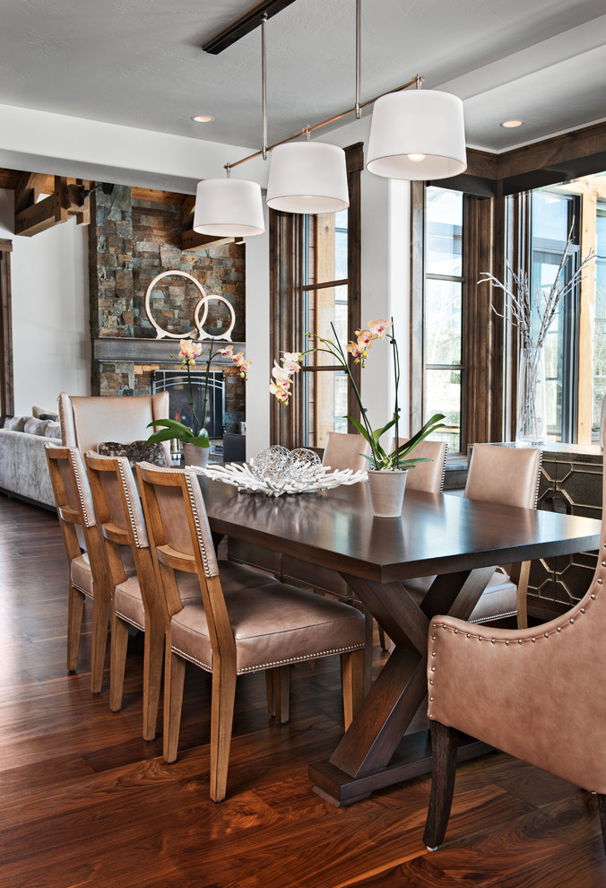 Esempio di una sala da pranzo aperta verso il soggiorno stile rurale con pareti bianche, parquet scuro e pavimento marrone