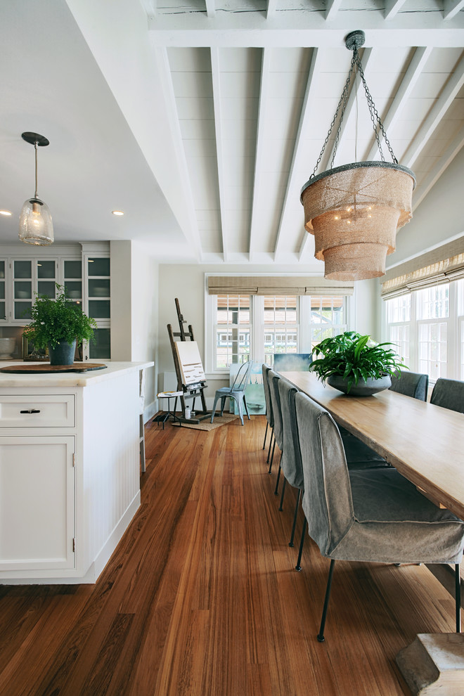 Idée de décoration pour une salle à manger ouverte sur la cuisine marine avec un mur beige, parquet foncé et un sol marron.