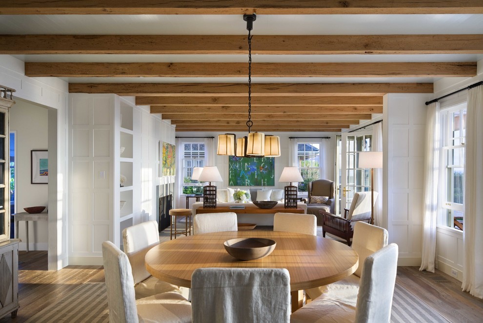 Example of a large beach style light wood floor and beige floor dining room design in Boston with a standard fireplace