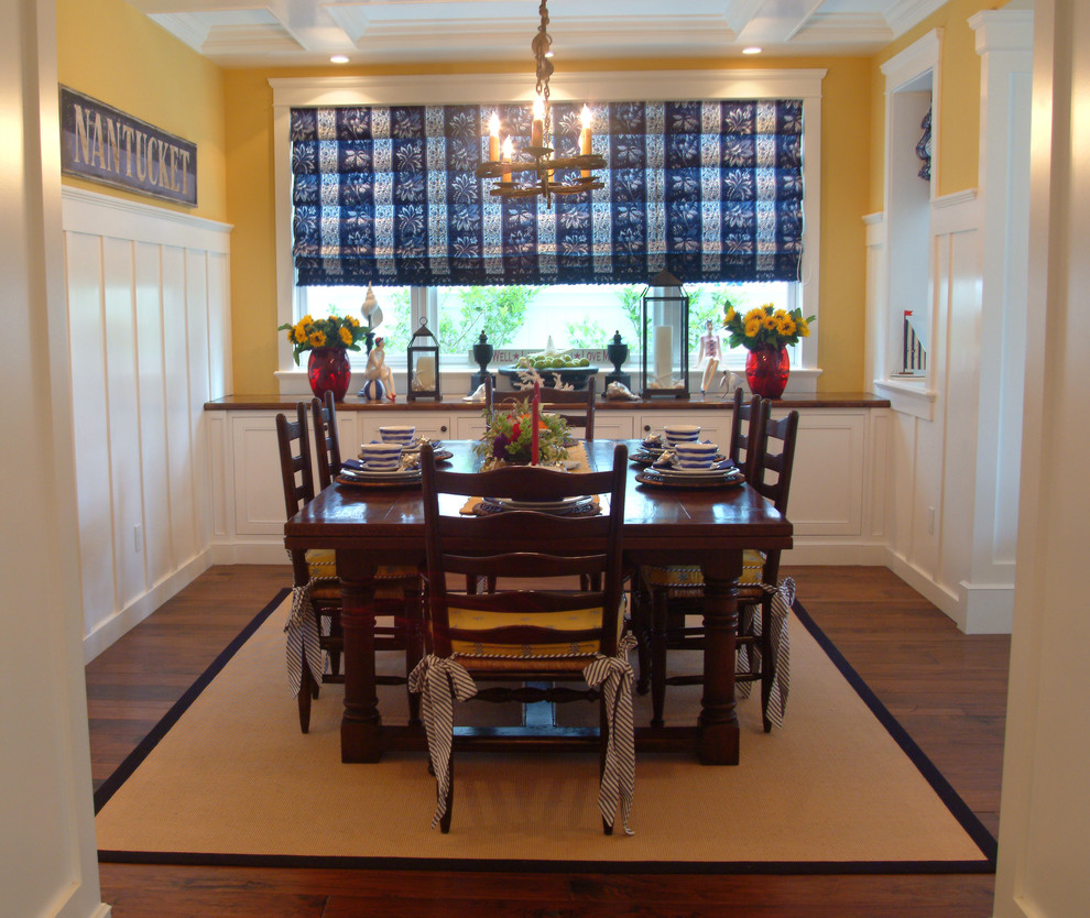 Foto di una sala da pranzo stile marinaro chiusa con pareti gialle e parquet scuro