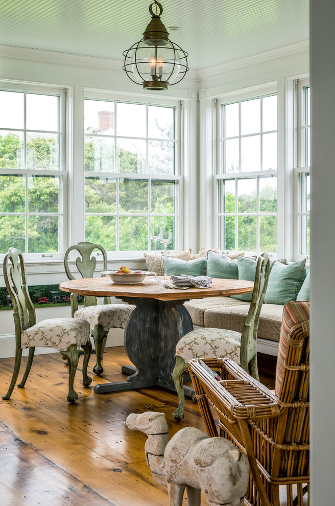 Foto di una sala da pranzo aperta verso la cucina stile marino con pareti bianche e pavimento in legno massello medio