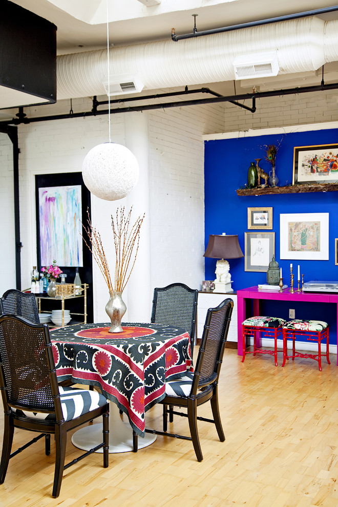 Idée de décoration pour une salle à manger bohème avec un mur bleu et parquet clair.