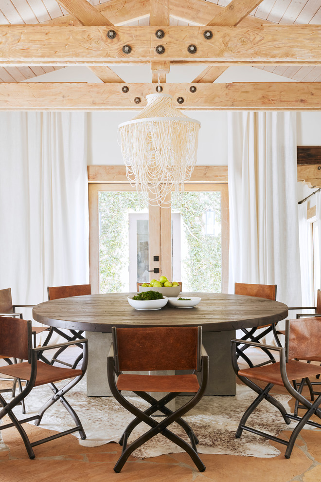 Example of a tuscan slate floor dining room design in Phoenix with white walls and no fireplace
