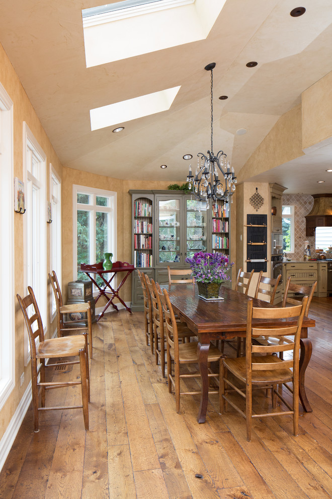 Réalisation d'une grande salle à manger ouverte sur la cuisine tradition avec un mur beige et un sol en bois brun.