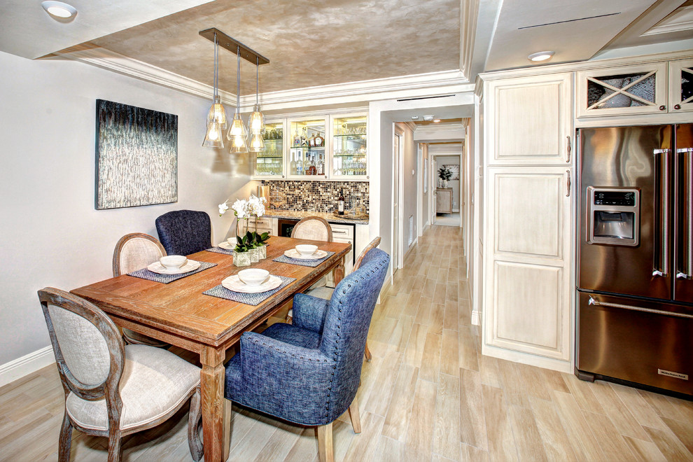 Immagine di una sala da pranzo aperta verso la cucina chic di medie dimensioni con pareti grigie, parquet chiaro, pavimento marrone e soffitto ribassato