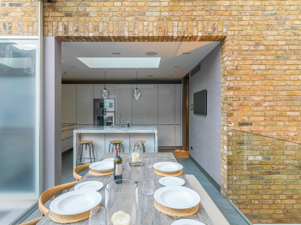Idee per una grande sala da pranzo aperta verso il soggiorno tradizionale con pareti gialle, pavimento in pietra calcarea e pavimento grigio
