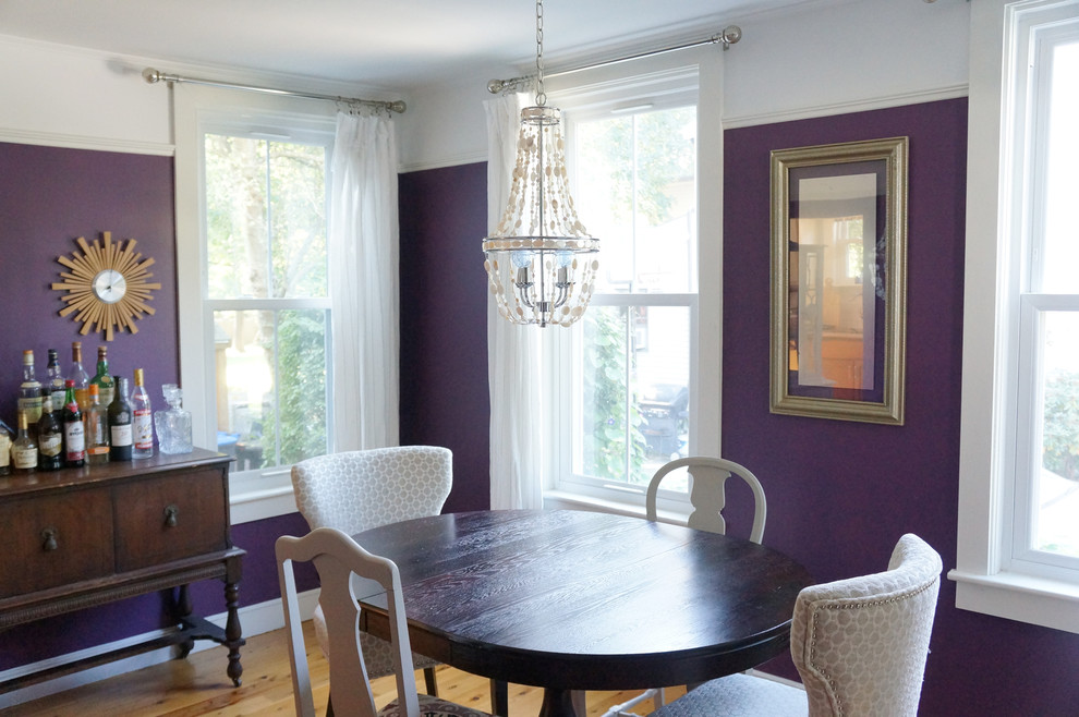 Cette photo montre une salle à manger éclectique fermée et de taille moyenne avec un mur violet et parquet clair.