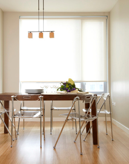 Immagine di una sala da pranzo aperta verso il soggiorno minimalista di medie dimensioni con pareti beige, parquet chiaro e nessun camino