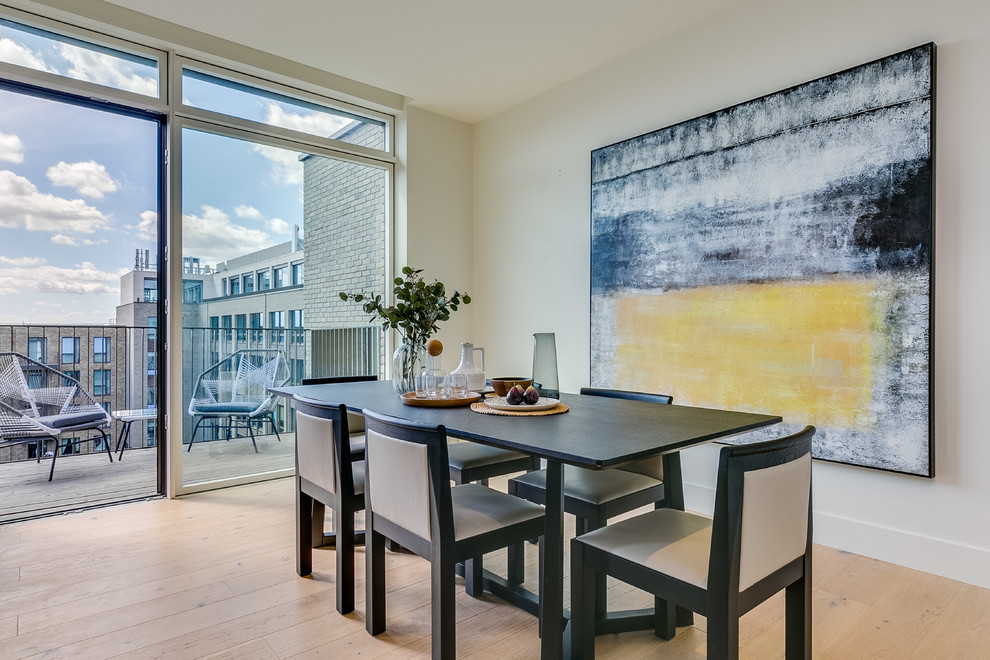 Medium sized contemporary enclosed dining room in London with light hardwood flooring, beige floors and grey walls.