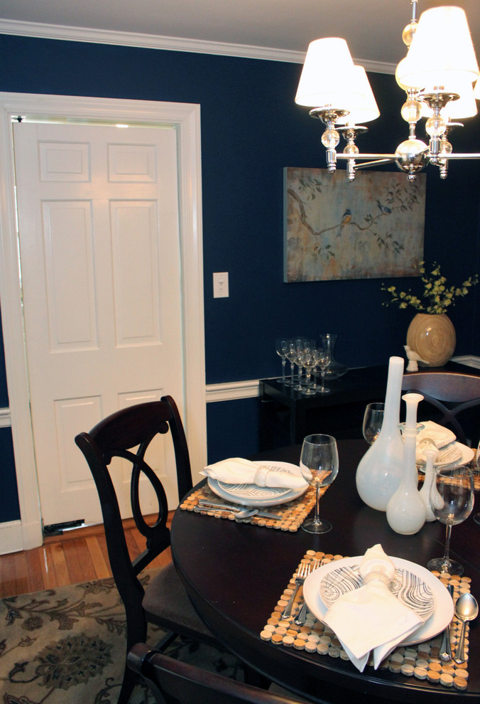 Exemple d'une petite salle à manger chic fermée avec un mur bleu, parquet clair et aucune cheminée.