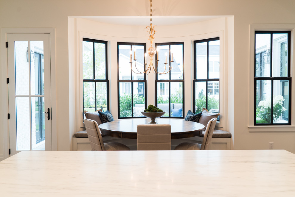 Aménagement d'une salle à manger ouverte sur la cuisine classique de taille moyenne avec un mur blanc, un sol en bois brun et aucune cheminée.