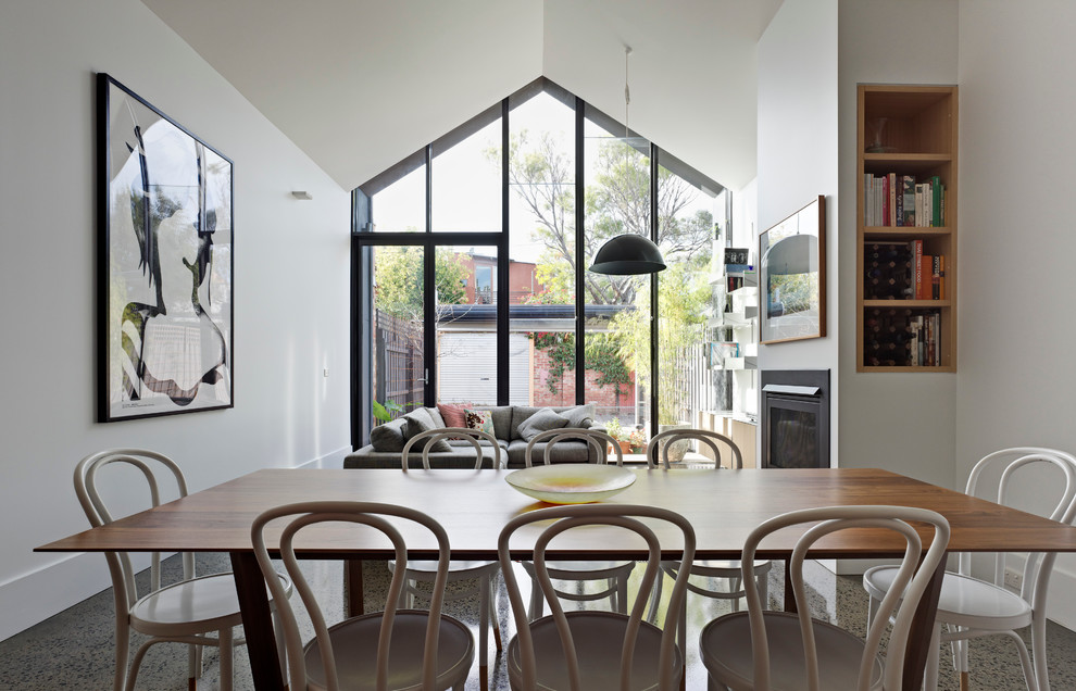 Aménagement d'une petite salle à manger ouverte sur le salon contemporaine avec un mur blanc, une cheminée standard et un manteau de cheminée en métal.