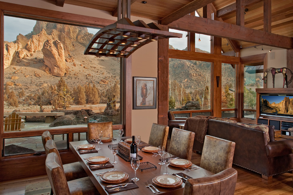 Idée de décoration pour une salle à manger ouverte sur le salon chalet avec un mur beige et parquet foncé.
