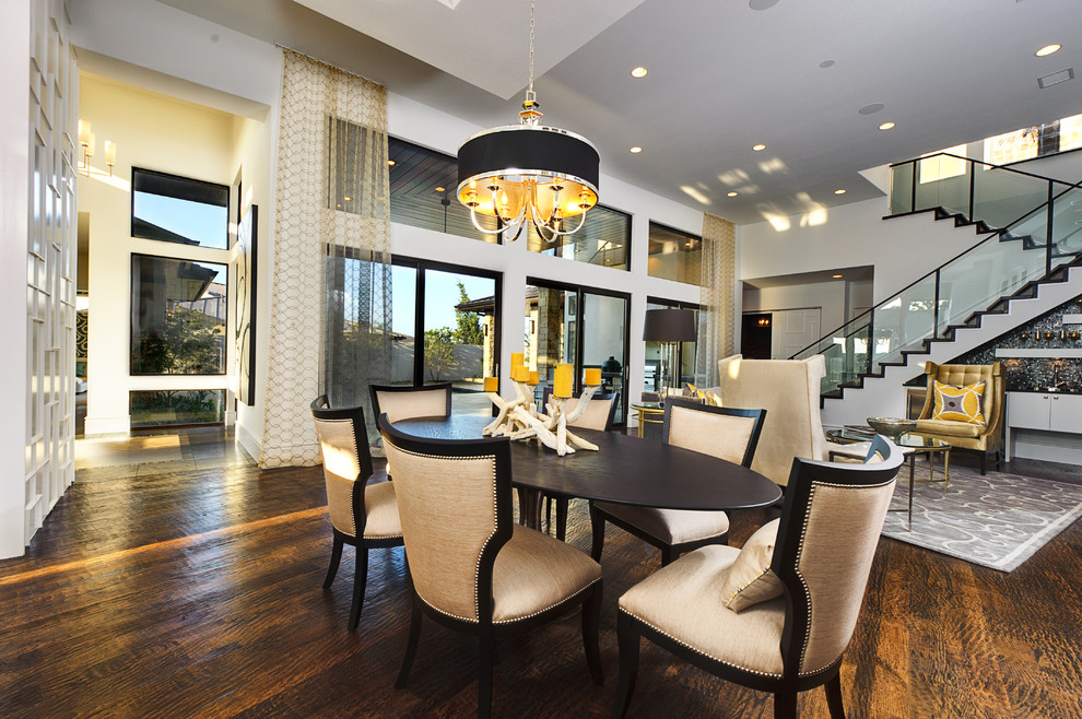 This is an example of a large classic open plan dining room in Austin with white walls, no fireplace, dark hardwood flooring, brown floors and feature lighting.