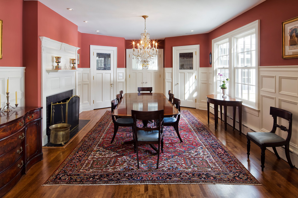 Geschlossenes, Geräumiges Klassisches Esszimmer mit roter Wandfarbe, braunem Holzboden, Kamin und Kaminumrandung aus Holz in New York