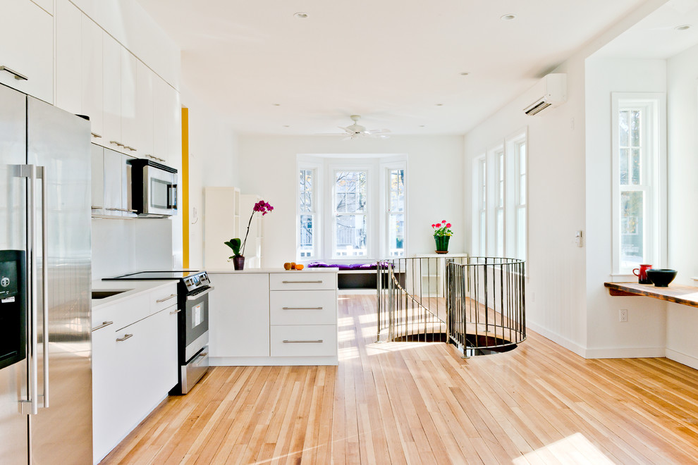 This is an example of a medium sized contemporary kitchen/dining room in Boston with white walls and light hardwood flooring.