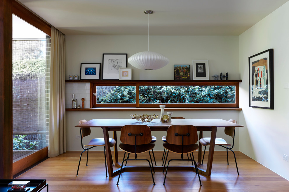 Design ideas for a medium sized midcentury dining room in Sydney with white walls and medium hardwood flooring.