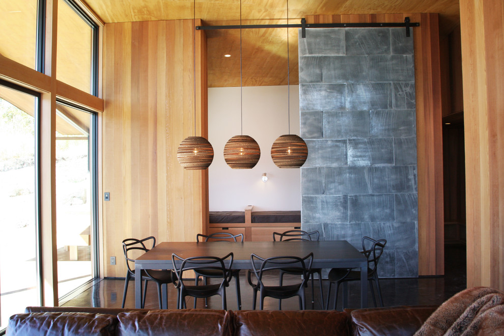 Diseño de comedor moderno de tamaño medio abierto sin chimenea con paredes metalizadas y suelo de cemento