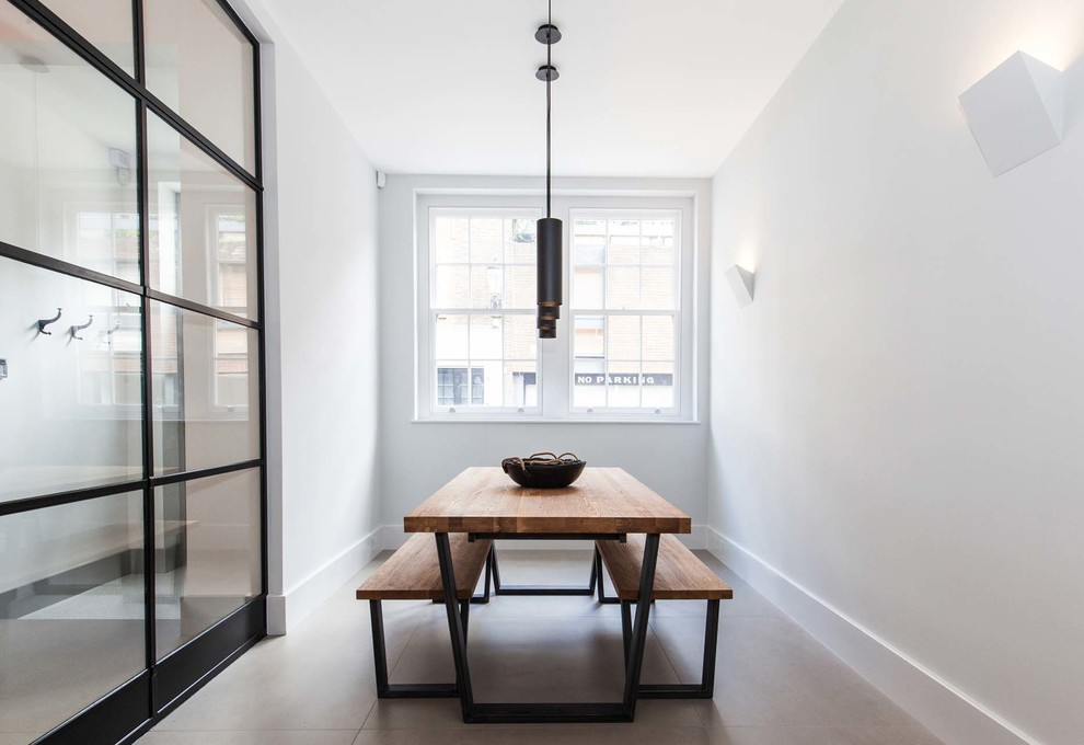Urban concrete floor and gray floor enclosed dining room photo in Kent with white walls