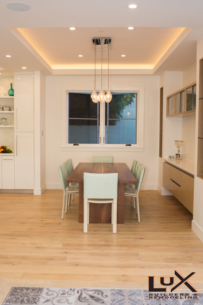Diseño de comedor moderno con paredes blancas y suelo de madera clara
