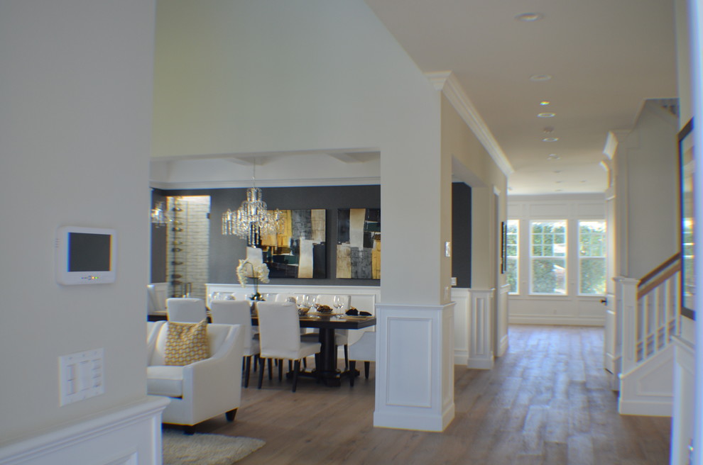 Cette photo montre une salle à manger ouverte sur le salon chic de taille moyenne avec parquet clair, un mur bleu, une cheminée standard, un manteau de cheminée en brique et un sol marron.