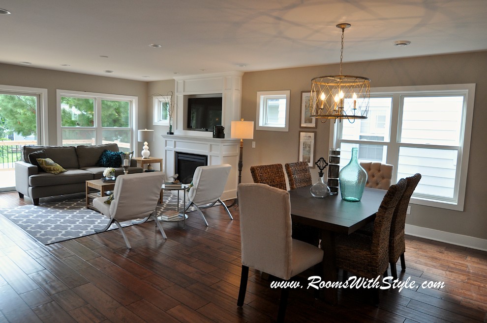 Idée de décoration pour une salle à manger ouverte sur le salon minimaliste de taille moyenne avec un mur gris et un sol en bois brun.
