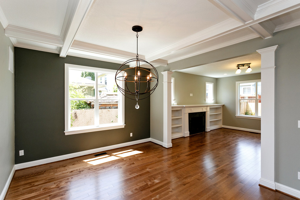 Exemple d'une salle à manger ouverte sur le salon craftsman de taille moyenne avec un mur vert et un sol en bois brun.