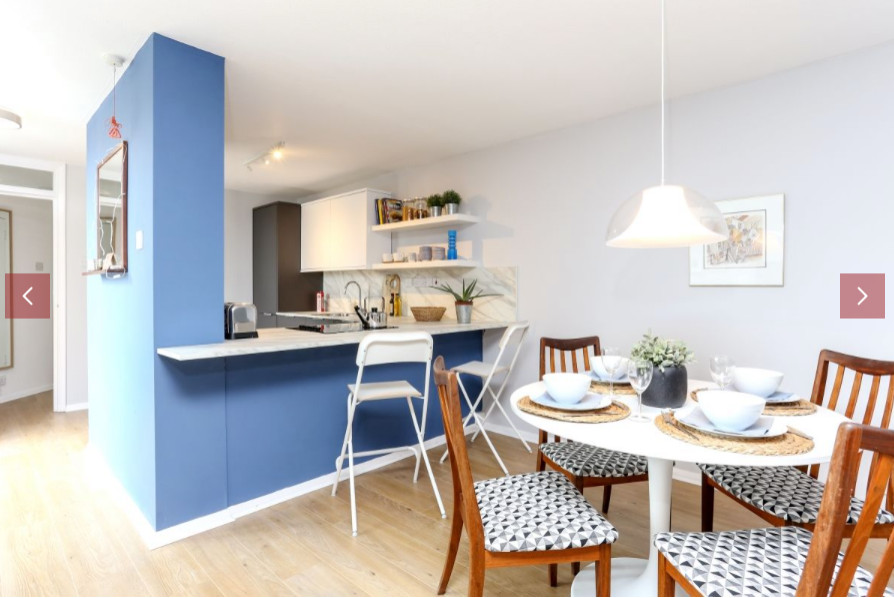 Medium sized scandinavian kitchen/dining room in London with blue walls and light hardwood flooring.