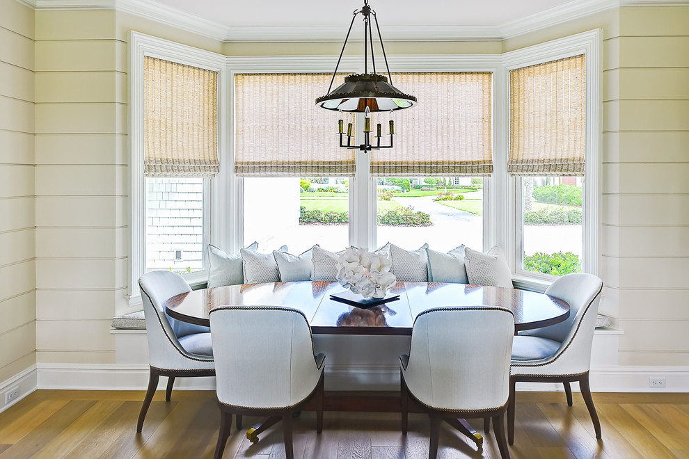 Idee per una sala da pranzo aperta verso il soggiorno chic con pavimento in legno massello medio, pareti beige e pavimento marrone